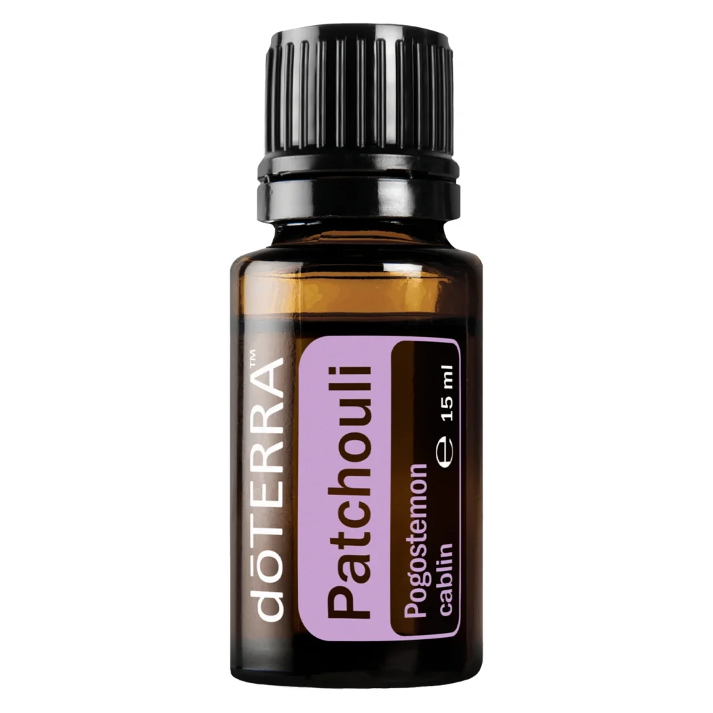 Frasco de Aceite Patchouli doTERRA sobre fondo natural con hojas de pachuli.